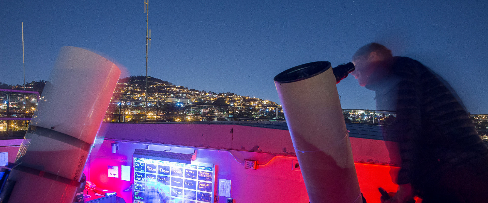 student looking through night time telescope