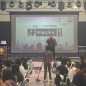view of presenter in front of screen at SF Hacks event