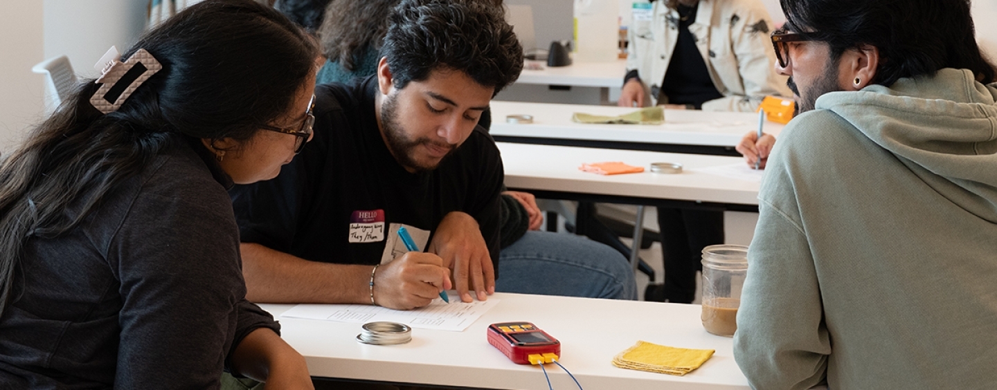 Three students at a table working on an activity together in the classroom