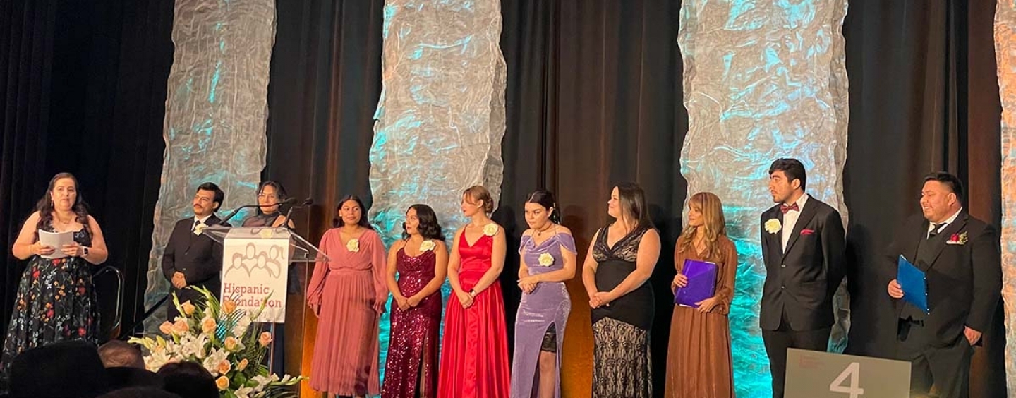 scholars on stage in formal wear to accept awards