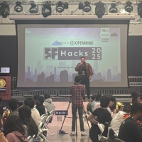 view of presenter in front of screen at SF Hacks event