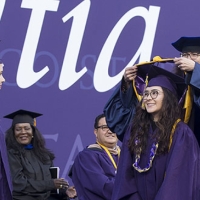 students receive their hoods at graduation ceremony