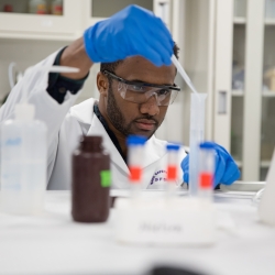 A chemistry student using a pipette
