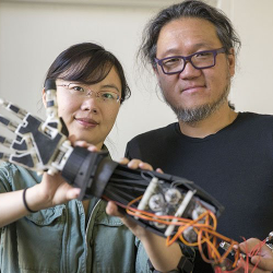 engineering instructor working with a robotic hand