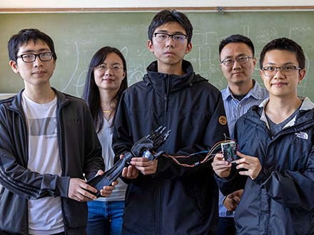 SF State faculty with some of the student researchers holding their bonic arm and Sony microprocessor.